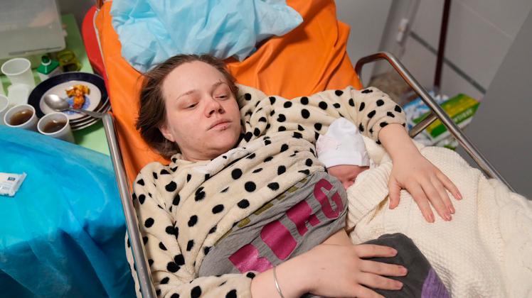 Marianna Podgurskaya hält kurz nach dem Angriff auf eine Kinderklinik in Mariupol ihre kleine Tochter in den Armen.