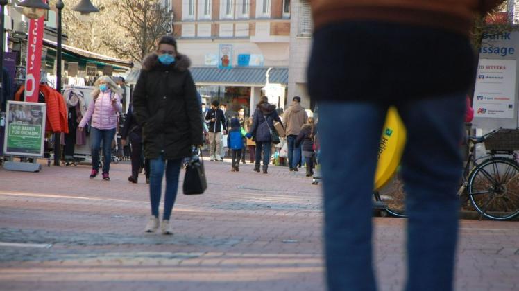 Passanten im Schleswiger Stadtweg tragen eine Maske.