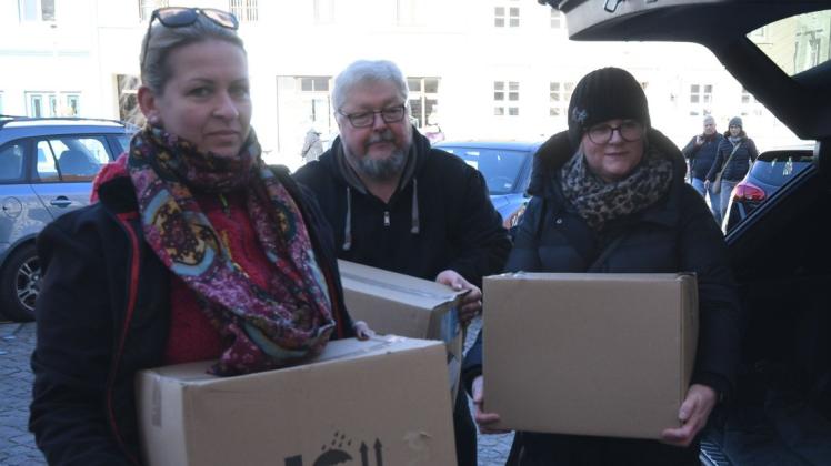 Steffi Müller, Thomas Domres und Nicole Bahr bringen Pakete mit Desinfektionsmitteln in die Sammelstelle.