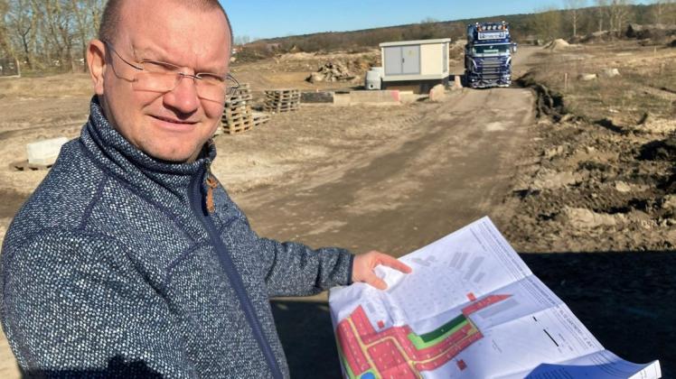 Mit dem Bauplan in der Hand erklärt Lutz Geltmeier von der Erschließungsfirma, dass im zweiten Abschnitt des Wohngebietes "Alte Gärtnerei" am Pfahlweg in Güstrow 40 Eigenheime entstehen.