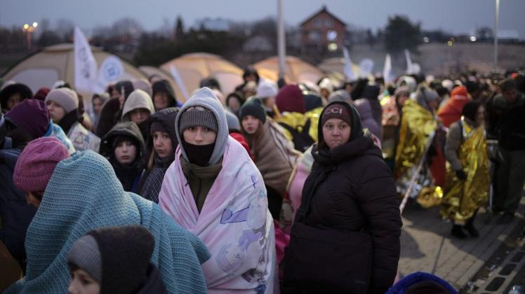 Flüchtlinge warten in einer Menschenmenge auf den Transport, nachdem sie aus der Ukraine geflohen und am Grenzübergang in Medyka, Polen, angekommen sind.