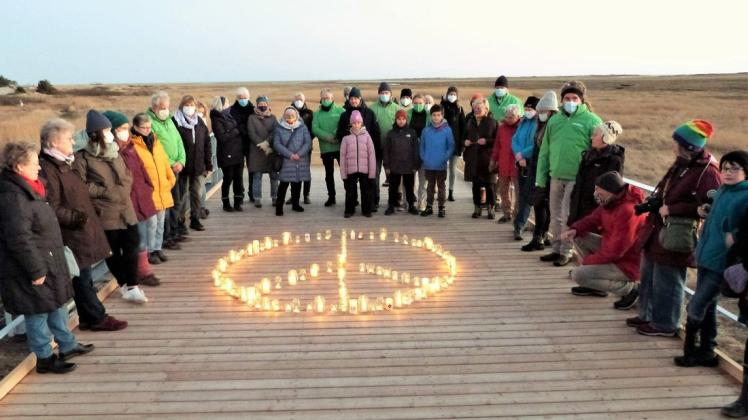 Mit einem Peace-Zeichen aus Kerzen gedachten die Menschen auf der Buhne in St. Peter-Ording den von Krieg betroffenen Ukrainern.