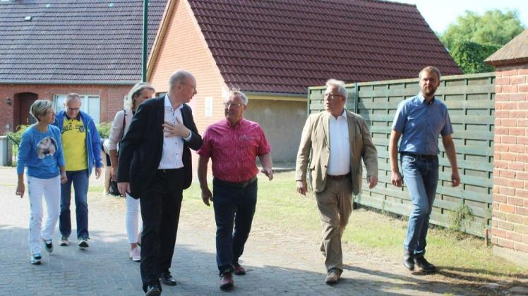 Rundgang in Sukow im Sommer 2021: Minister Cristian Pegel, Bürgermeister  Horst-Dieter Keding und Gemeindevertreter schauen sich den zukünftigen Standort für den digitalen Dorfladen am Dorfplatz an.