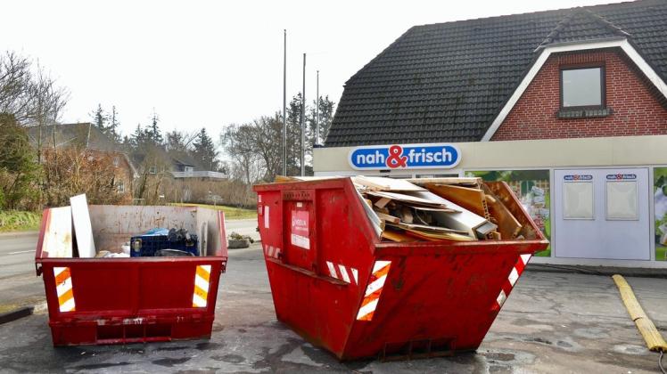 Aufräumarbeiten: Volle Abfallbehälter vor dem geschlossenen Markt in Schobüll.