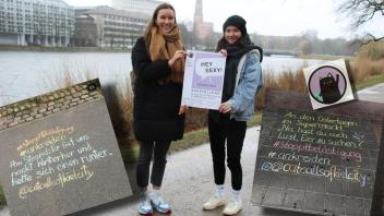 Kira und Annabel von "catcallsofkielcity" präsentieren am Kleinen Kiel das Plakat für die Ausstellung. Mit shz.de sprachen sie über  ihre Motivation und persönliche Erfahrungen zum Thema sexualisierte Belästigung.