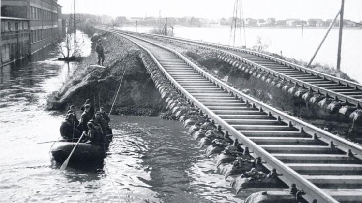 Weggespült: Der Bahndamm am Alsengelände, der auch als Stördeich diente, wurde durch die Sturmflut in der Nacht zum 17. Februar 1962 abgetragen. Helfer begutachten die Schäden vom Boot aus.