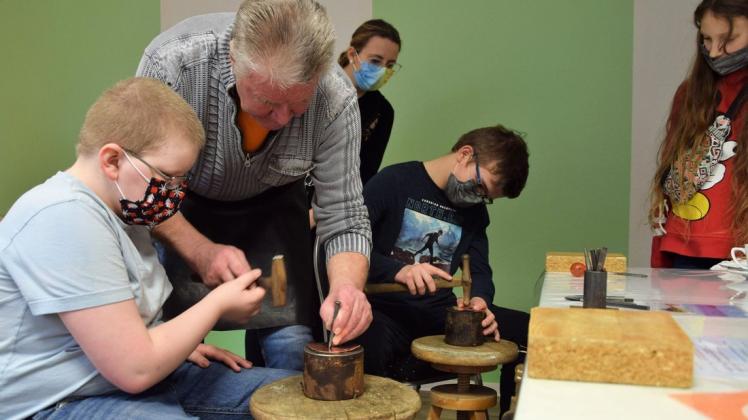Wie kommt das Muster ins Kupfer? Jürgen Paul zeigt den Ferienkindern, wie sie das Metall bearbeiten können.
