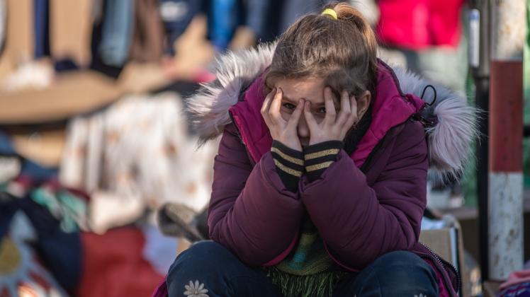Ein Mädchen, das vor dem Krieg in der Ukraine geflohen ist, hält ihren Kopf als Zeichen der Erschöpfung im Flüchtlingslager Medika in Polen in ihren Händen. Ein Mädchen, das vor dem Krieg in der Ukraine geflohen ist, hält ihren Kopf als Zeichen der Erschöpfung im Flüchtlingslager Medika in Polen in ihren Händen.