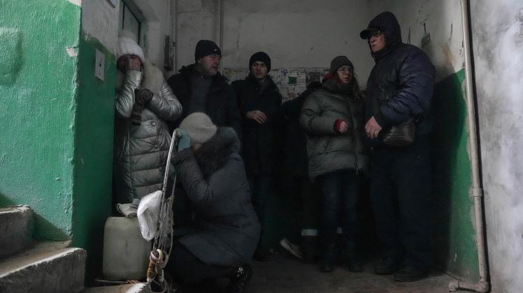 Einwohner in Mariupol schützen sich vor Beschuss im Eingang eines Wohnhauses. In der Stadt halten die russischen Streitkräfte ein großes Krankenhaus besetzt.