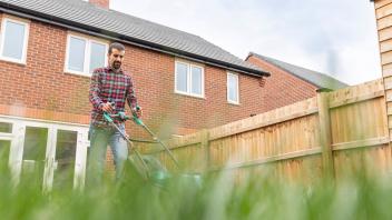 Man mowing lawn with lawn mower at backyard model released Symbolfoto PUBLICATIONxINxGERxSUIxAUTxHUNxONLY WPEF03418