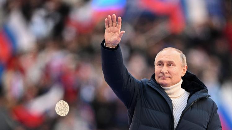 Russian President Vladimir Putin greets the audience as he attends a concert marking the eighth anniversary of Russia&apos;s annexation of Crimea at the Luzhniki stadium in Moscow on March 18, 2022. (Photo by Ramil SITDIKOV / POOL / AFP)