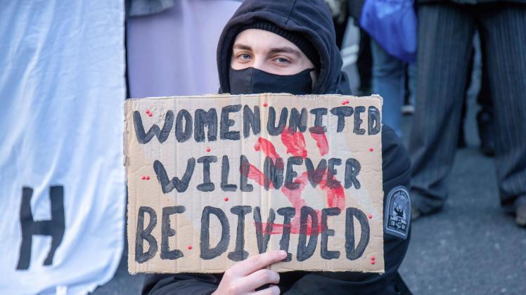 March 12, 2022, London, United Kingdom: A protester holds a sign saying Women United Will Never Be Divided during the de