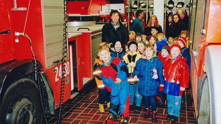 Eine Gruppe von Kindergartenkindern und ihren Erzieherinnen vor einem Einsatzauto der Feuerwehr. 