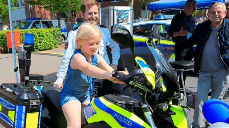 Die achtjährige Celina aus Ganderkesee sitzt auf einem Polizei-Motorrad Probe. 
