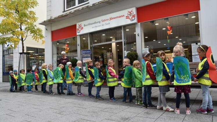 Buchhändlerin Sabine Jünemann empfängt die größte Raupe der Stadt, gebildet von der Mäuschengruppe des Ev. Kindergartens Stickgras. Foto: Marco Julius
