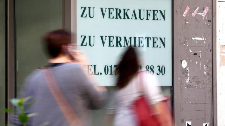 ARCHIV - 18.09.2018, Nordrhein-Westfalen, Oberhausen: An einem leerstehenden Ladenlokal gehen Passanten vorbei. (Zu dpa «Attraktivität mittelmäßig: Deutschlands Innenstädte haben ein Problem») 