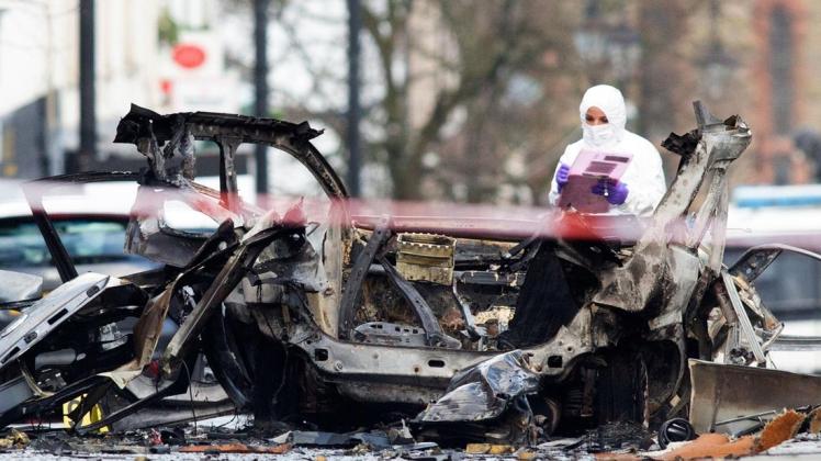 Forensiker untersuchen das Autowrack. Die Polizei vermutet einen politischen Hintergrund.