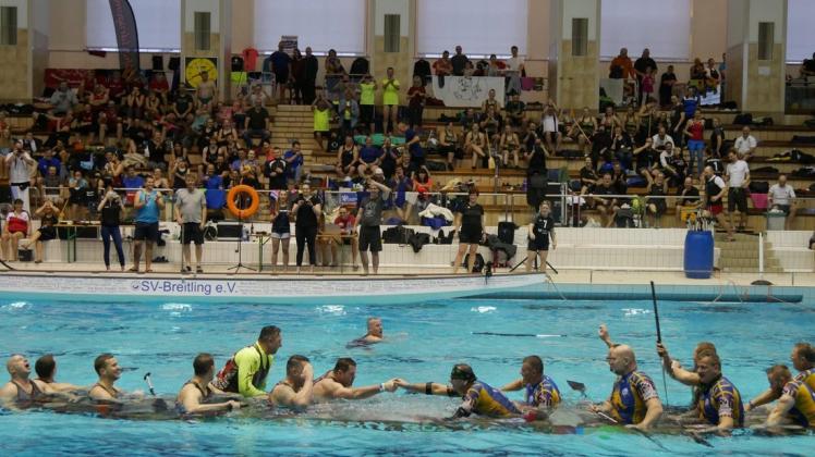 Zwei Team gehen baden: „Amber Szczecin“ aus Stettin und „Lucky Punch“ aus Lübeck schaufelten sich in einem sehr langen und intensiven Rennen so viel Wasser in das Boot, dass es schließlich – passend zu den Klängen des Titanic-Liedes –  mit den noch immer kämpfenden Sportlern im Schwimmbecken unterging.