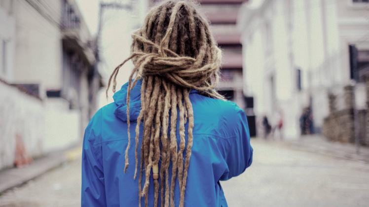 Young man in the streets with long dreadlocks using blue jacket Brazil, State of Santa Catarina ,editorial use only PUBL