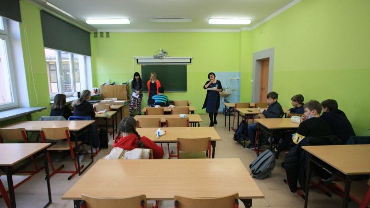 Schüler, die aus der Ukraine geflohen sind, sitzen in einem Klassenraum,