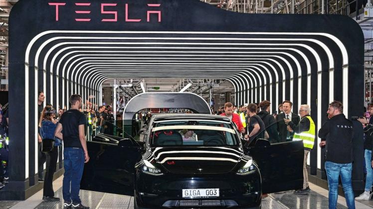 Tesla-Chef, Elon Musk, (3.v.r.),  übergibt persönlich ein Elektrofahrzeug  zur Eröffnung der Fabrik an den Besitzer.