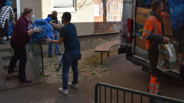 Palwasha, Tina und Samer helfen Steve beim Entladen des Transporters vor der Kleiderkammer für Geflüchtete in Wismar.