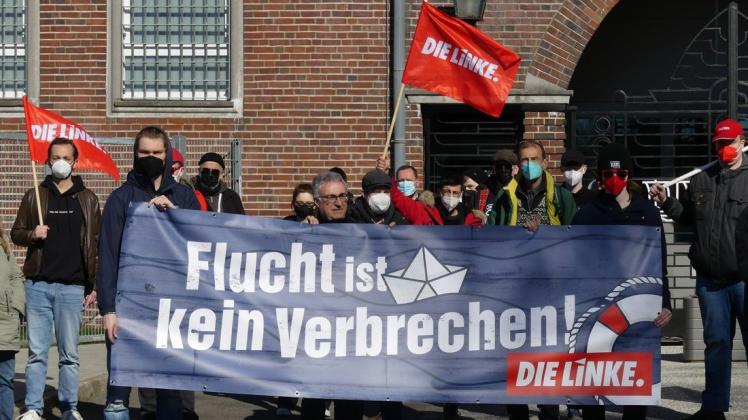 Mit Bannern und dem Slogan „Flucht ist kein Verbrechen“ haben Teilnehmer einer Versammlung der Partei Die Linke gegen die Glückstädter Abschiebehaftanstalt protestiert.