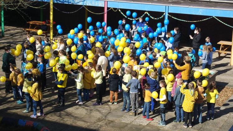 Blau-gelbes Zeichen für den Frieden: Die Schüler der Aukamp-Schule lassen am Freitag Luftballons in den ukrainischen Farben fliegen.