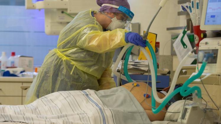 Eine Krankenschwester betreut auf der Intensivstation eines  Krankenhauses einen Covidpatienten.