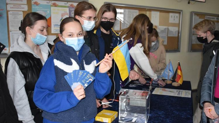 Tombola für die Ukraine-Hilfe im Innerstädtischen Gymnasium Rostock: Die 14-jährige Paulina Colditz aus der Klasse 8a demonstriert Solidarität mit der Ukraine. Die 8a hatte die Idee zur Tombola.
