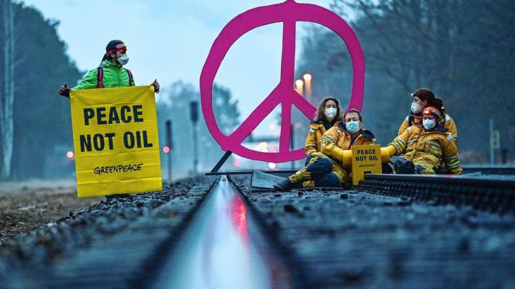 Aktivisten von Greenpeace blockieren am frühen Morgen ein Bahngleis zur Erdölraffinerie der PCK-Raffinerie GmbH.