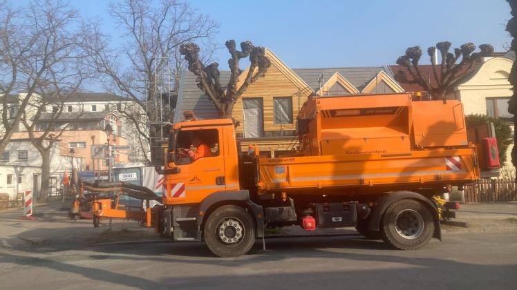 Das orangefarbene Fahrzeug der Straßenmeisterei vom Tiefbauamt ist derzeit für Reparaturarbeiten in der Warnemünder Mühlenstraße unterwegs.