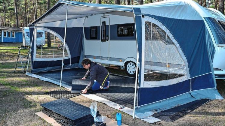 Daniel Barentin, Camper, bereitet seinen Wohnwagen auf dem Campingplatz am Schervenzsee im Naturpark Schlaubetal auf die beginnende Saison vor.