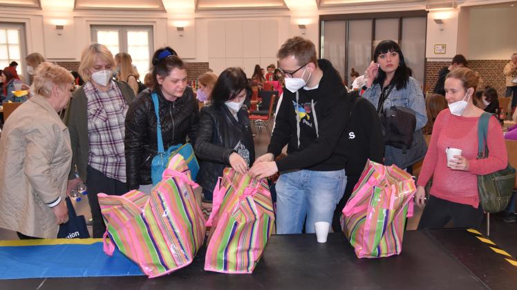 Helfer überreichen Geflüchteten bei einem Treffen in der Delmenhorster Markthalle Spenden und Geschenke.