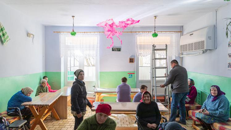 Was schwebt da unter der Decke? In einem Fürsorgeheim in der Ukraine hat Künstler Aljoscha eine seiner schwebenden Glasskulpturen angebracht. Der Künstler reist durch das Kriegsgebiet und installiert seine Kunstwerke in Schulen und Fürsorgeeinrichtungen. Foto: Aljoscha