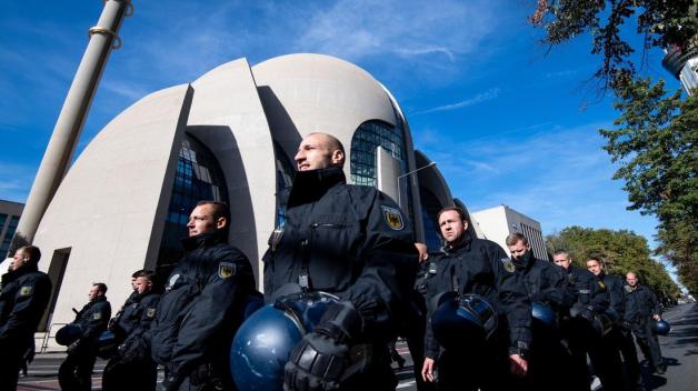 Polizisten sichern das Gelände vor der Ditib-Zentralmoschee. Foto: dpa/Marius Becker Polizisten sichern das Gelände vor der Ditib-Zentralmoschee. Foto: dpa/Marius Becker
