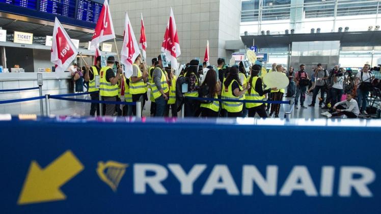 Mitarbeiter der Fluglinie Ryanair haben sich zu einem 24 Stunden dauernden Warnstreiks vor dem Check-in Schalter der irischen Fluggesellschaft versammelt haben. Foto: dpa/Silas Stein