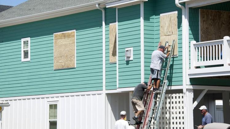 In North Carolina versuchen diese Männer, ein Haus vor dem nahenden Hurrikan "Florence" zu schützen. Foto: Imago/Jason Moore