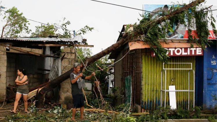Anwohner räumen eine verwüstete Straße auf, nachdem der Taifun "Mangkhut" wütete. Foto: dpa/Aaron Favila