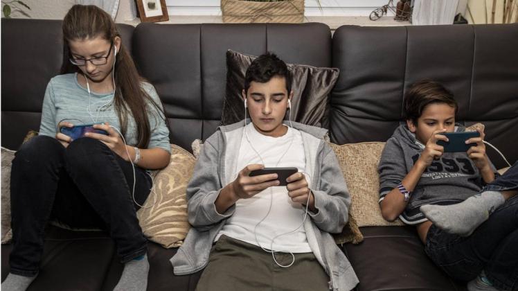 Technisch enorm fit, aber Probleme mit der Rechtschreibung: Jugendliche mit ihren Smartphones. Foto: imago/Bo van Wyk