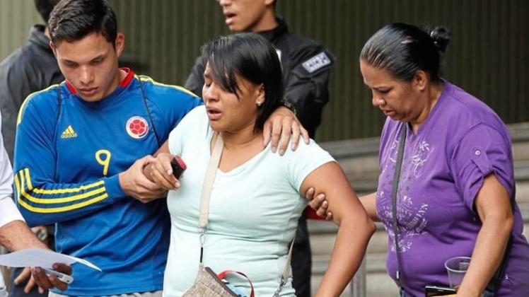 Eine Überlebende wird nach ihrer Aussage bei der Polizei von Familienangehörigen begleitet. Nach der Explosion einer Tränengasgranate in einem Nachtclub in Venezuela sind mindestens 17 Menschen ums Leben gekommen. 
