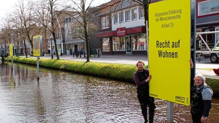 Die neuen, signalgelben Amnesty International-Schilder sind von Roland Averdung und Erich Wulfhorst (rechts) installiert worden. 