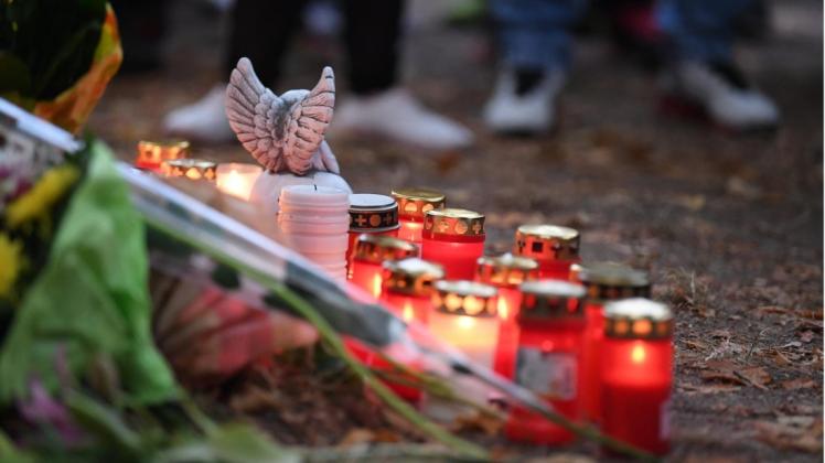 Blumen und Kerzen stehen an einem Baum auf einem Spielplatz, in dessen Nähe ein 22-Jähriger bei einem Streit zwischen zwei Männergruppen ums Leben gekommen ist.  Foto: Hendrik Schmidt/dpa-Zentralbild/dpa