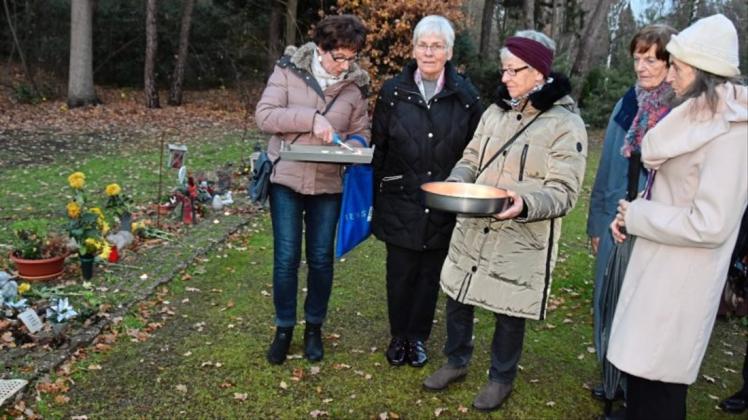 Entzünden Lichter für die anonym Bestatteten: Predigtlektorin Barbara Stolberg (rechts) und eine Gruppe Ehrenamtlicher auf dem Friedhof Bungerhof. Entzünden Lichter für die anonym Bestatteten: Predigtlektorin Barbara Stolberg (rechts) und eine Gruppe Ehrenamtlicher auf dem Friedhof Bungerhof.