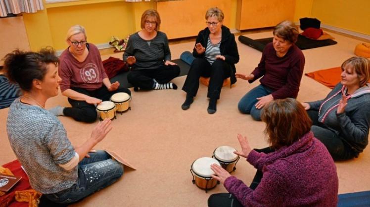 Im Kreis sitzend trommeln die Teilnehmerinnen einen einfachen Rhythmus, den Kursleiterin Claudia Hüner (links) vorgibt. Fotos: Hildegard Wekenborg-Placke