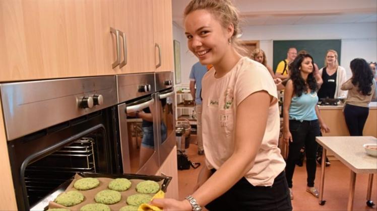Teilnehmerin Marina aus Tschechien schiebt die ersten vegetarischen Burger in den Ofen. 