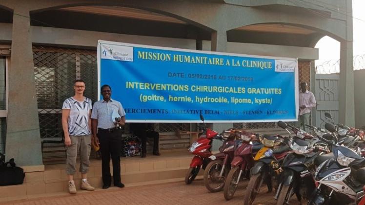 Ein Banner zeigt den Stolz auf die Unterstützung der Burkina Faso Intitiative Belm und der Niels-Stensen-Kliniken: Dr. Martin Gerdes und Prof. Gilbert Bonkoungou vor der Klinik in Ougadougou. 