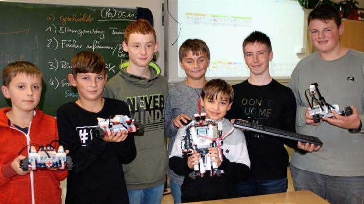 Jan-Ole Schrader (rechts) und seine Schulkameraden bringen den Robotern in Bookholzberg das Laufen, Fahren und Kämpfen bei. 