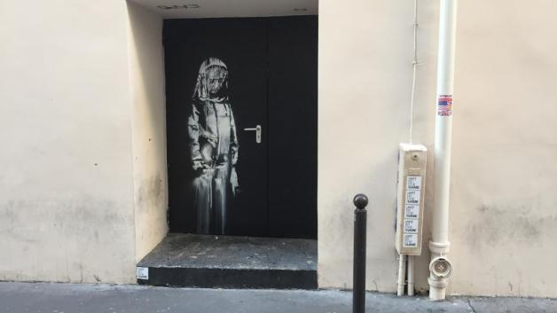 Auf einer Tür beim Pariser Musikclub "Bataclan" ist ein Wandbild zu sehen, das auch dem britischen Street-Art-Künstler Banksy zugerechnet wird. Foto: dpa/Sebastian Kunigkeit