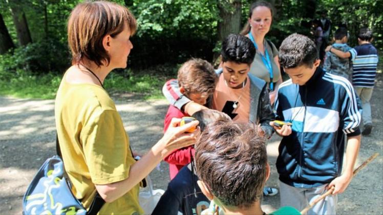 Carola Bartelheimer auf Schatzsuche mit den Kindern im Wald. 